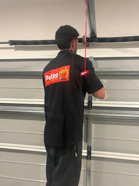 Peter Garage Doors technician replacing the torsion spring on a sectional garage door in Brisbane