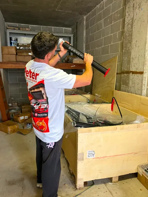 Peter Garage Doors technician preparing a new torsion spring for a garage door spring replacement in Perth